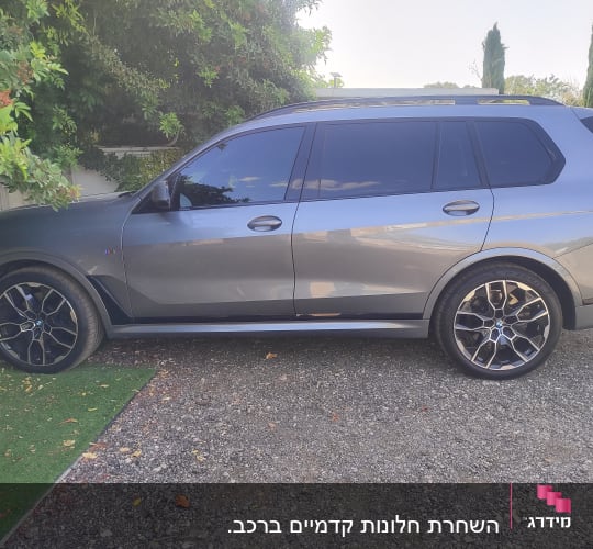 רכב אפור עם חלונות כהים וחישוקי גלגלים מעוצבים